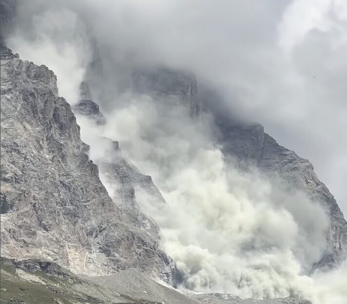 Rockfall tearing down a steep alpine face
