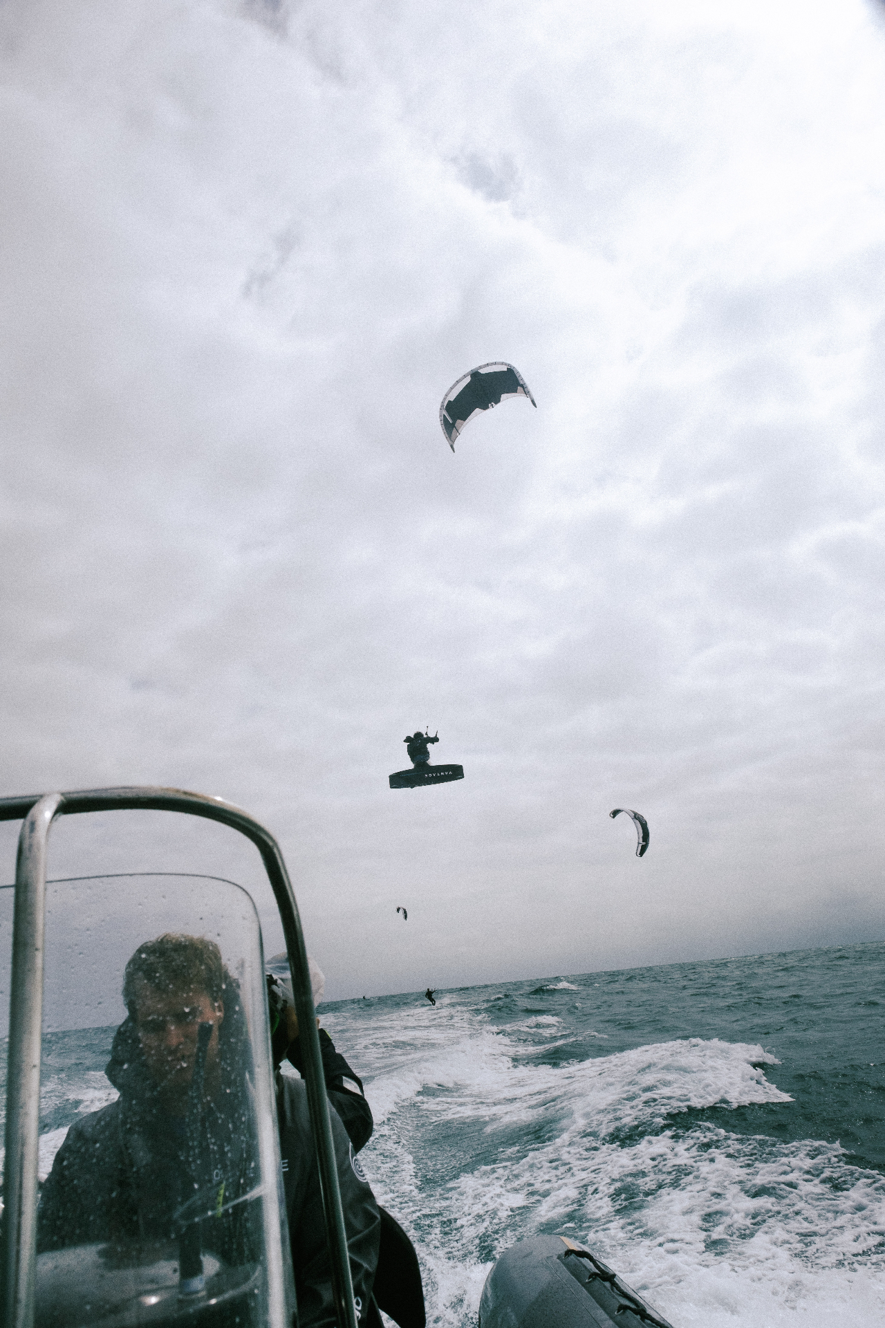 Kitesurfer airborne above the support boat