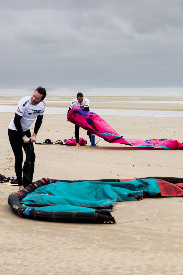 Riders pumping their kites on the beach at the Offshore Downwind